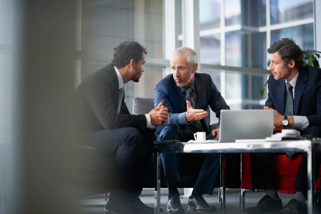 Three professionals collaborating and discussing ideas during a Change Management Courses Australia session