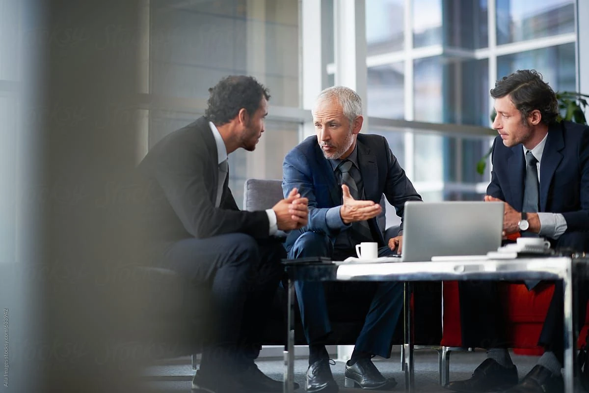 Three professionals collaborating and discussing ideas during a Change Management Courses Australia session
