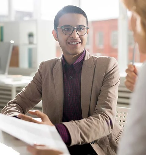 Two professionals discussing ideas during Change Management Courses Australia, with one wearing glasses and the other smiling